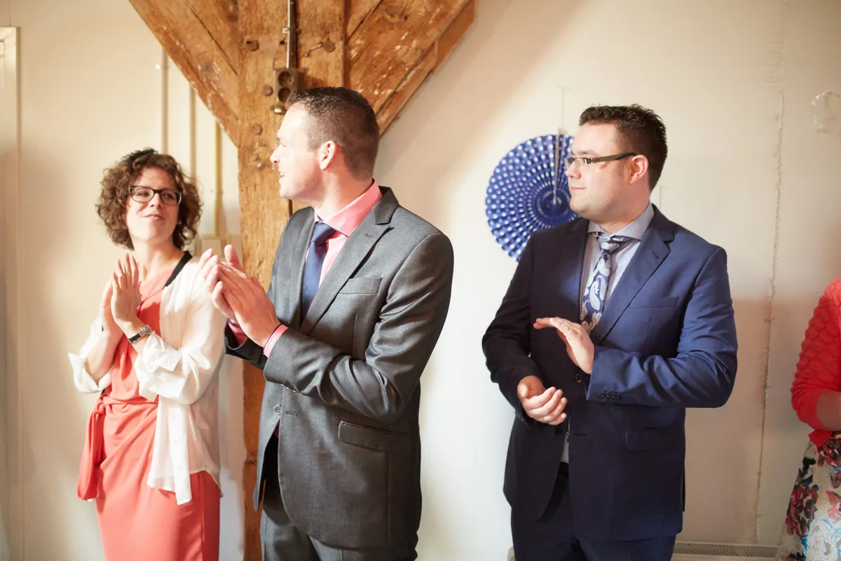 Gasten klappen voor het bruidspaar bij de lunch op de boerderij