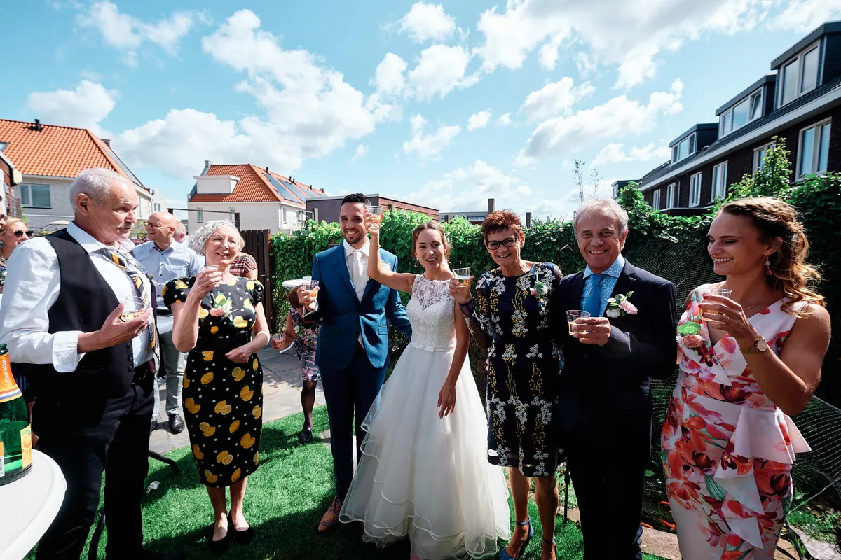 Tessa en Jeroen proosten met de daggasten op het gras
