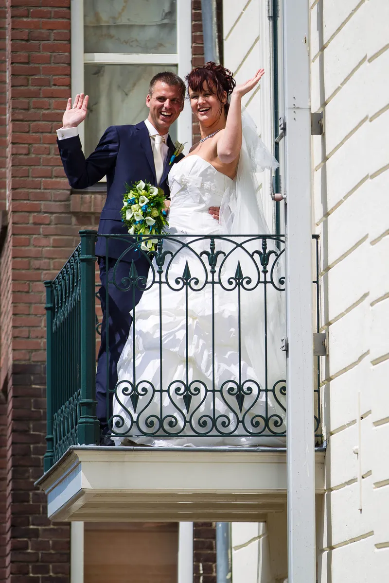 Anne en Hans zwaaien vanaf het balkon van het museum