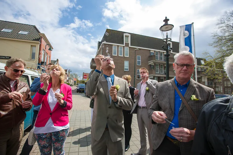 De gasten op de dijk kijken omhoog naar het balkon