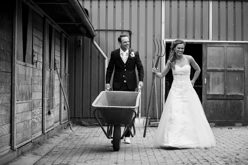 Trudy en Ron bij de stal met een kruiwagen, in zwart-wit