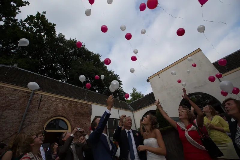 Gasten laten roze en witte ballonnen op