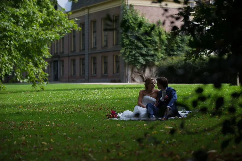 Karin en Wannes op een kleed in het gras, met het landhuis erachter