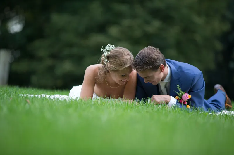 Karin en Wannes liggen lachend in het gras