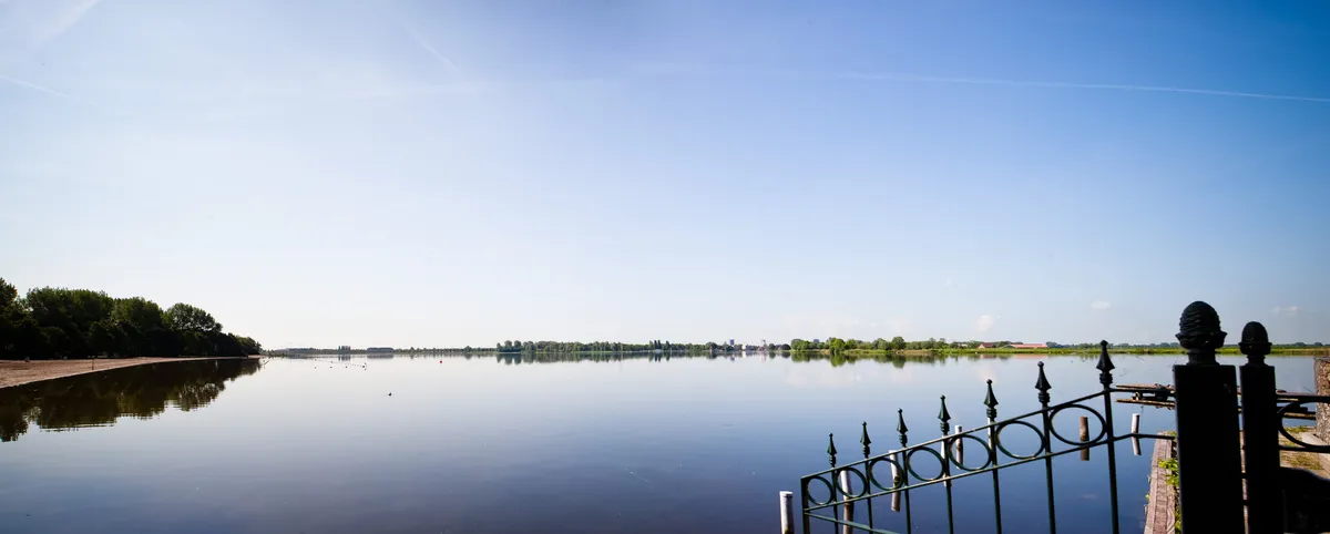 Het Noord Aa spiegelglad onder een blauwe lucht