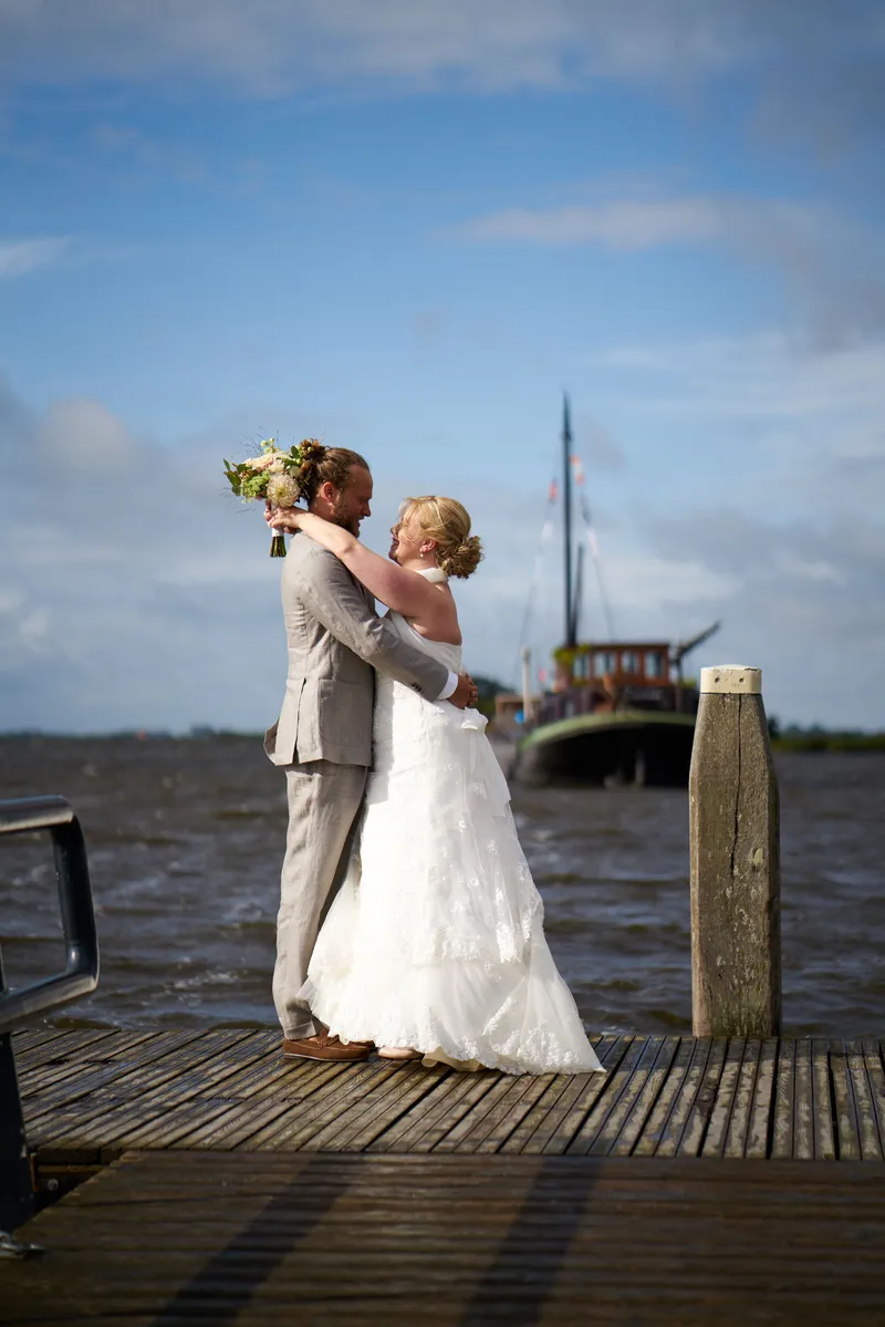 Akke en Rogier op het eind van de steiger, met een oude zeilboot erachter