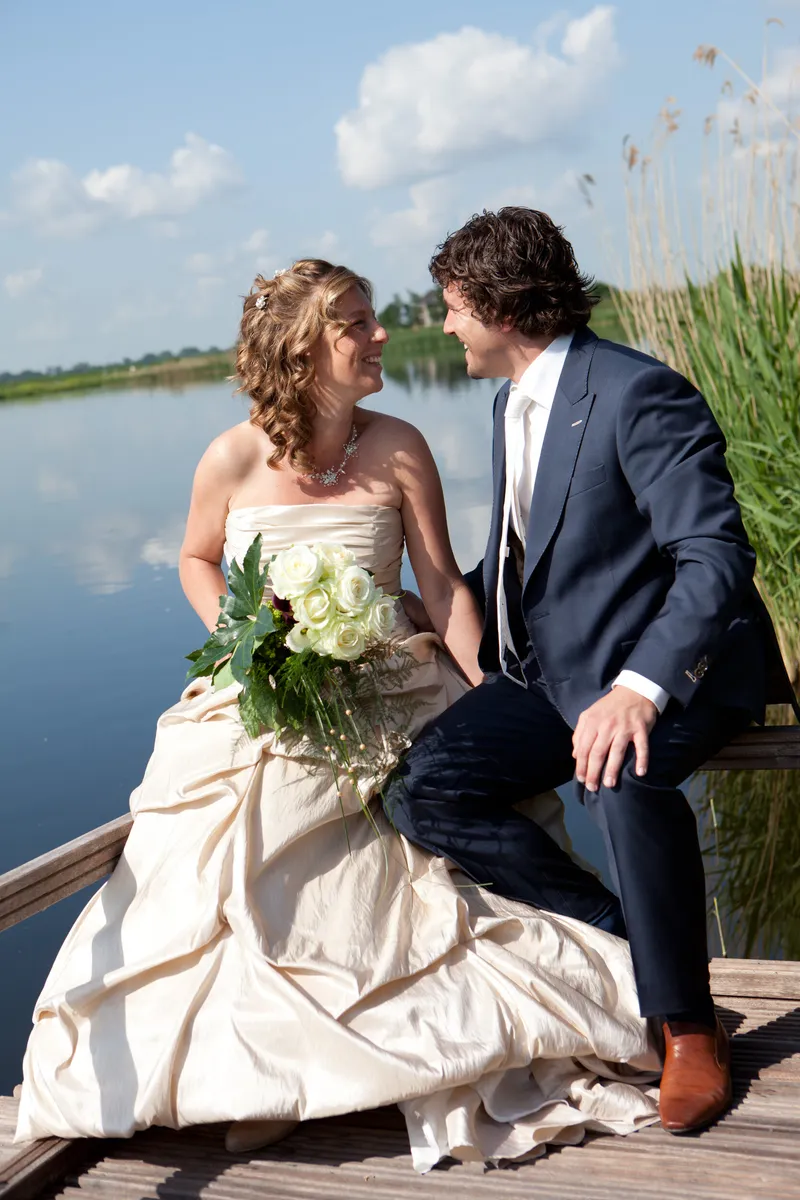 Patricia en Arno zitten op de steiger aan het water