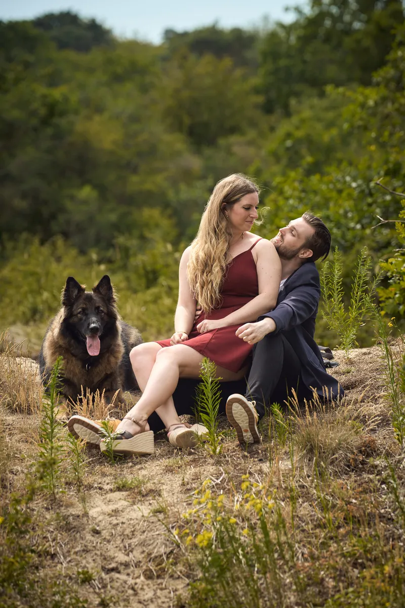 Kayleigh leunt op de schouder van Dimitri, de hond zit ernaast