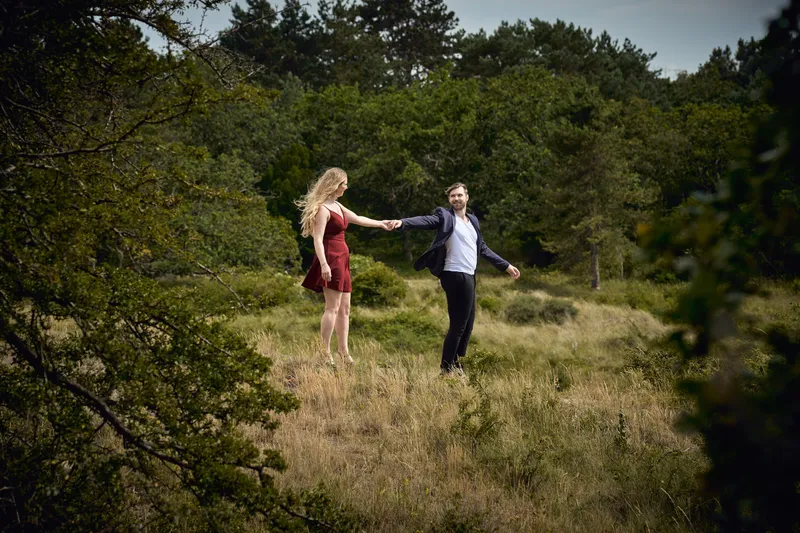 Dimitri en Kayleigh houden elkaars handen vast in het hoge gras