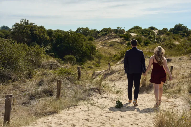 Dimitri en Kayleigh lopen over een zandpad tussen de duinen