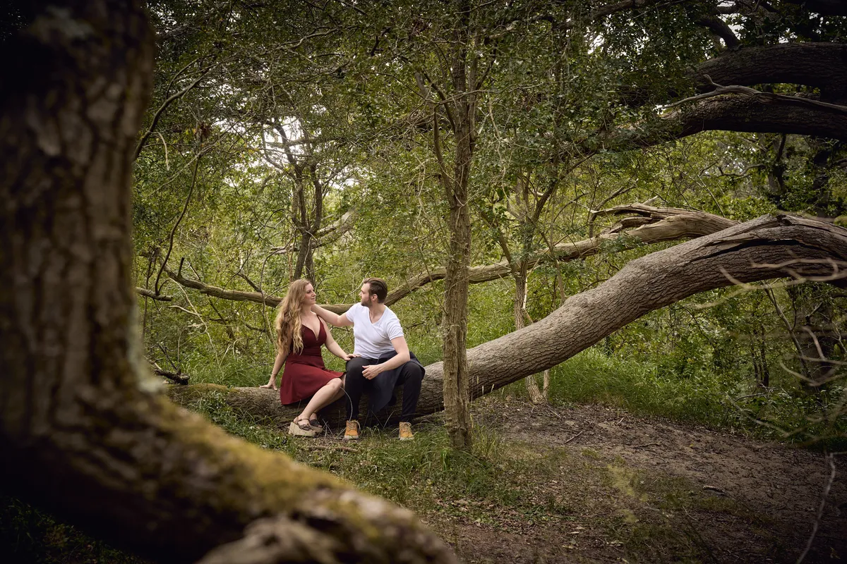 Dimitri en Kayleigh zitten op een omgevallen boom in het bos