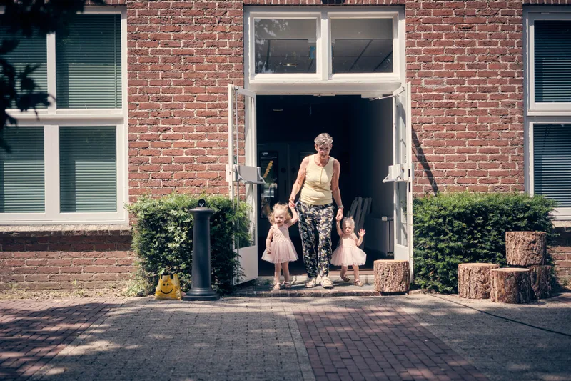 De twee dochtertjes komen in roze jurkjes het hotel uit