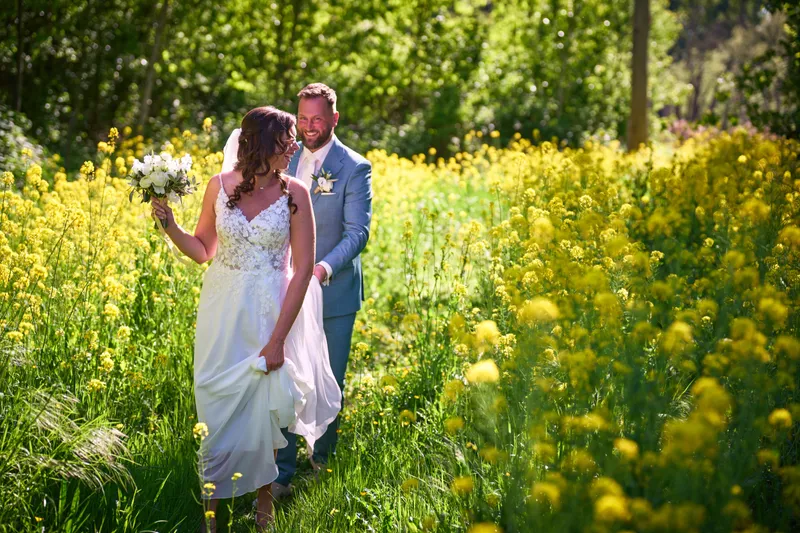 Michelle en Barrie tussen de gele bloemen in het Bergse Bos