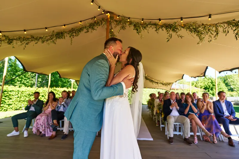 Michelle en Barrie kussen onder de tent tijdens de ceremonie
