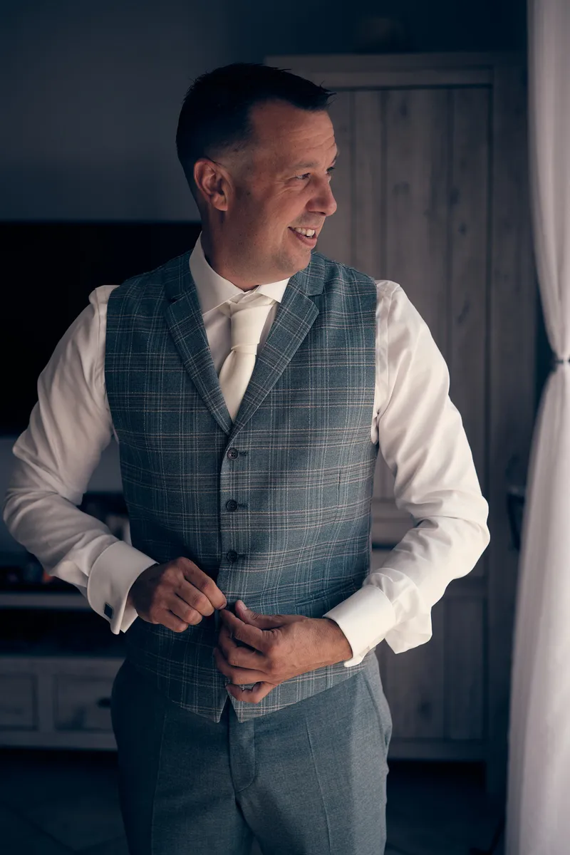 Michiel in zijn grijze gilet in de woonkamer