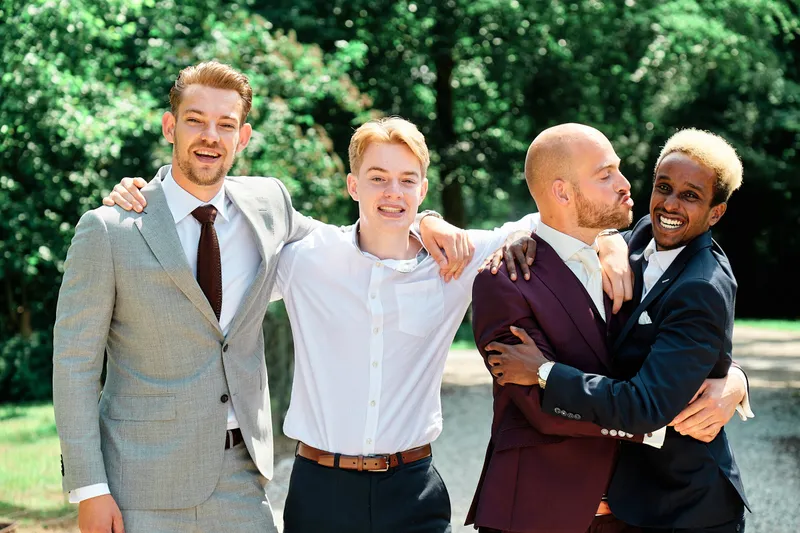 Simon en zijn vrienden lachen met de armen om elkaar heen