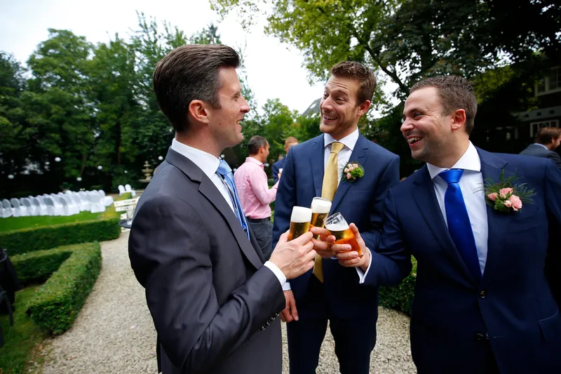 Drie vrienden proosten met een biertje
