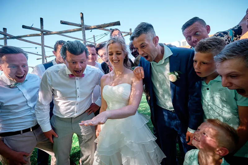 Ylona wordt omhelsd door lachende vrienden onder de pergola