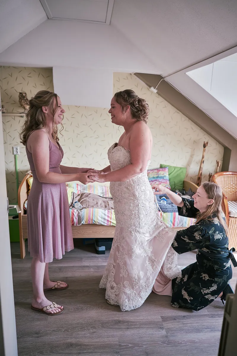 Mirjam in haar jurk in de slaapkamer, haar dochter helpt haar