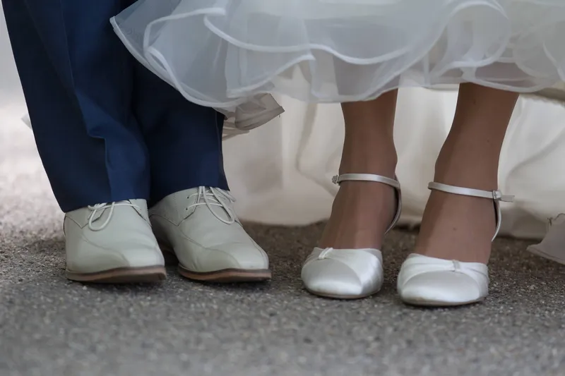 Zijn schoenen en haar trouwschoenen naast elkaar