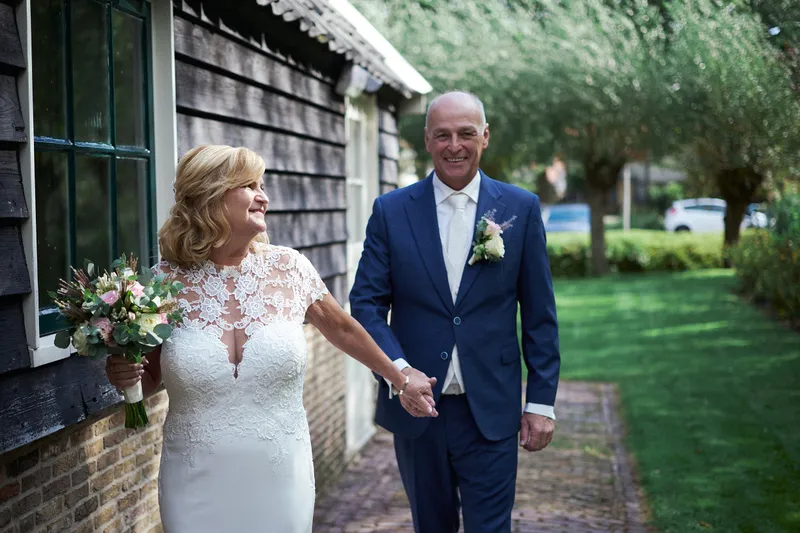 Jopie en Cees lopen hand in hand langs de zwarte schuur