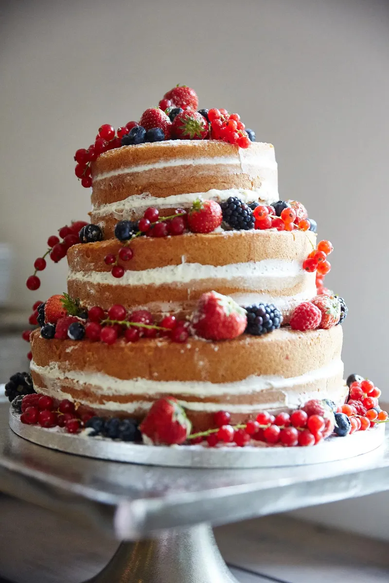 Een naked cake met lagen biscuit, room en rood fruit