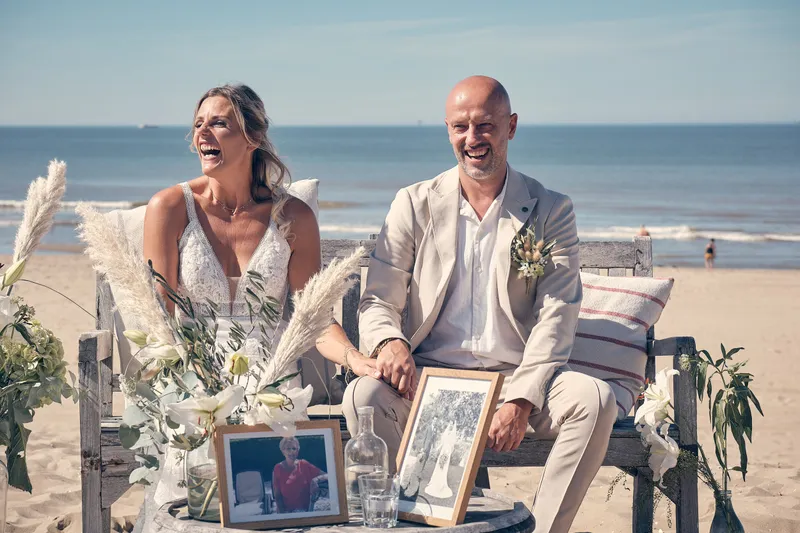 Fotolijstjes en bloemen op de bank tijdens de ceremonie