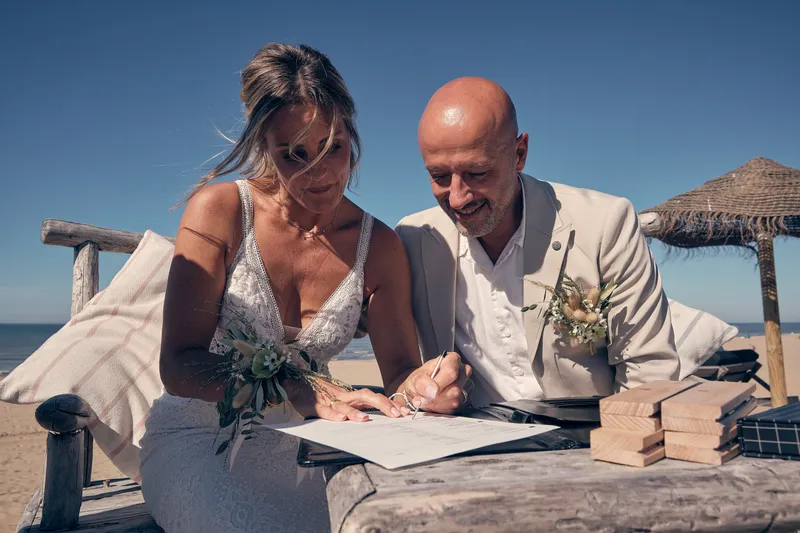 Jolanda en Pascal tekenen de akte op het strand