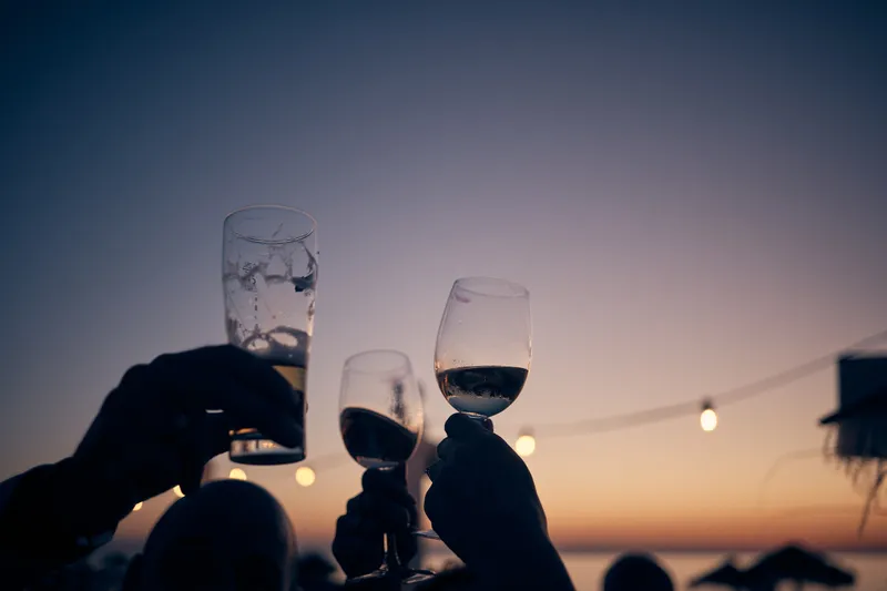 Glazen worden geheven tegen de avondlucht