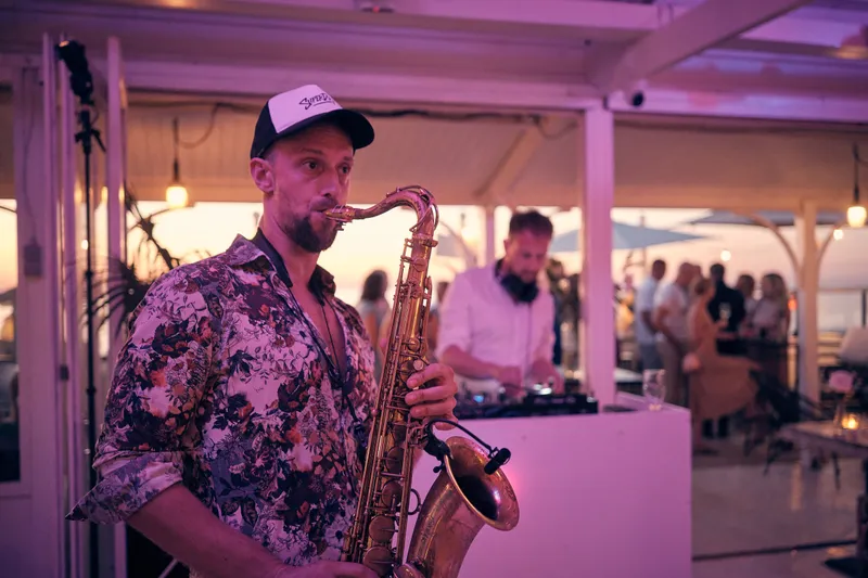 De saxofonist speelt op het feest
