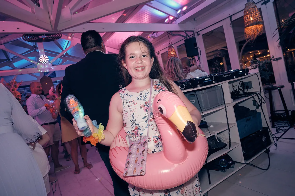 Een meisje met een opblaasflamingo op de dansvloer