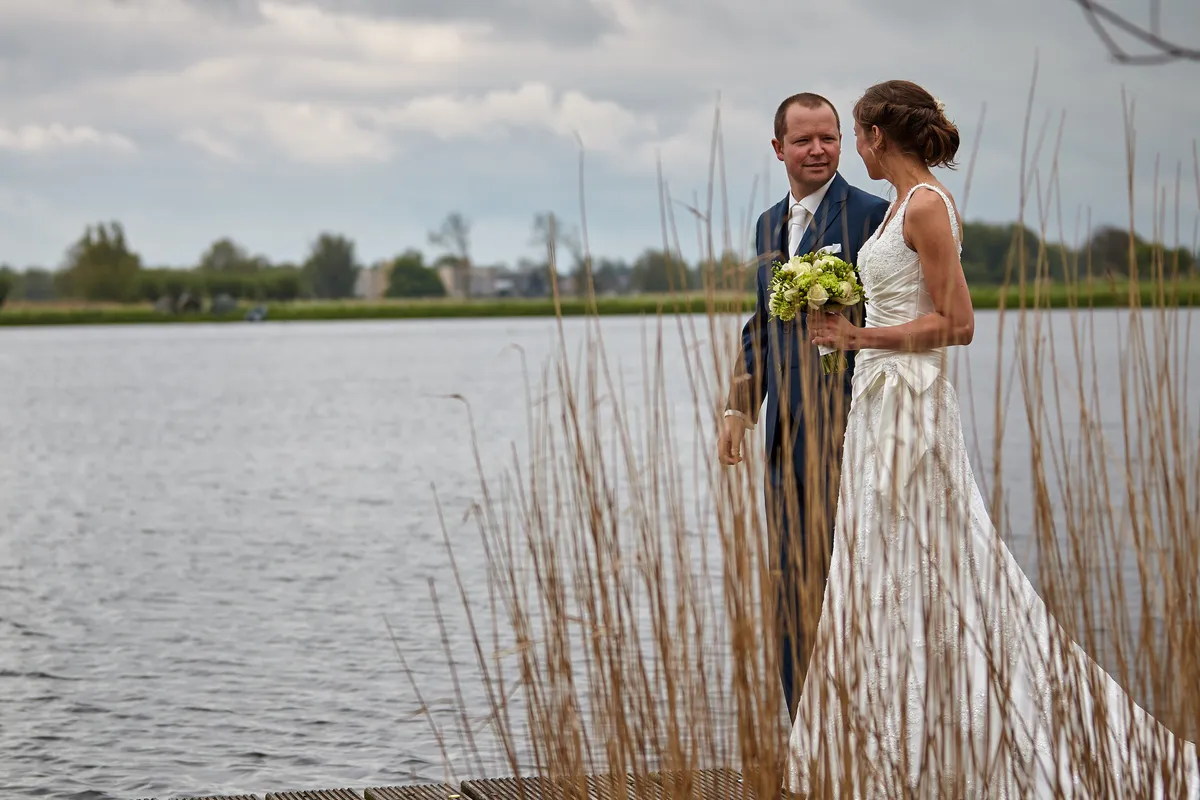 Elise en Maarten tussen het riet aan de plas