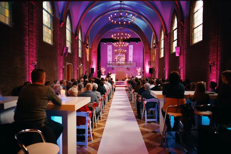 De zaal met de witte loper en het roze licht