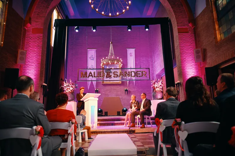 Het podium in De Noviteit met de namen van het bruidspaar in lichtletters