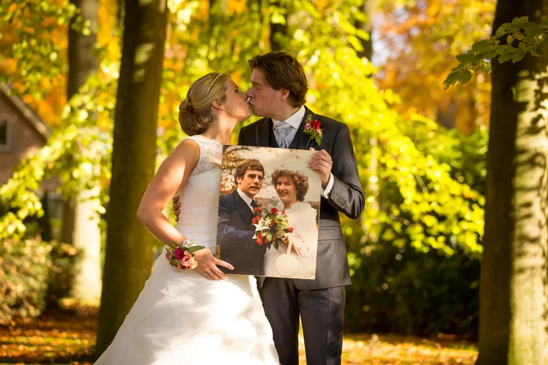 Ingeborg en Martijn in de tuin, met het gele blad om hen heen