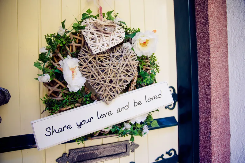 Een krans aan de voordeur met een bordje ‘Share your love’