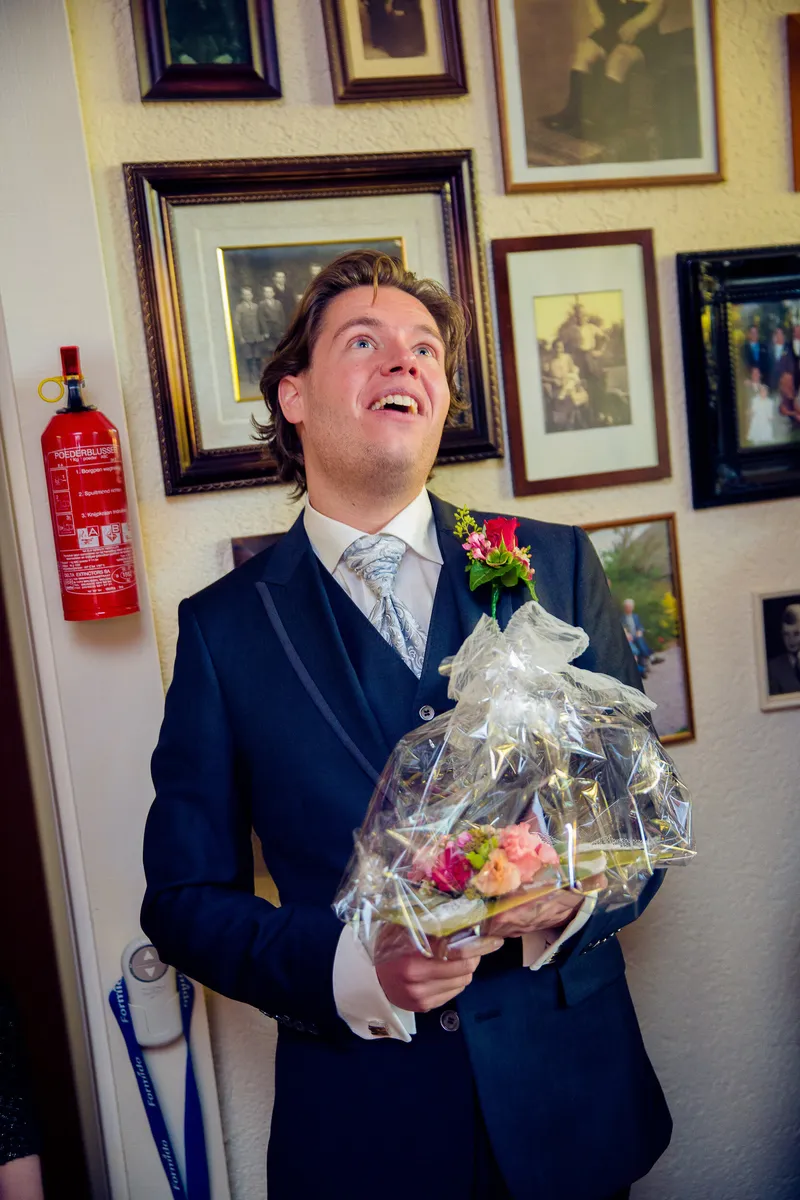 Martijn wacht met het boeket in de gang