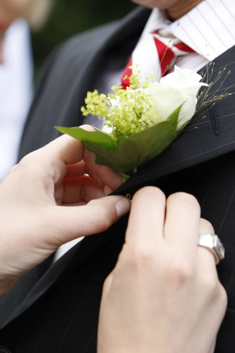 Het corsage wordt op het pak van Robert-Jan gespeld