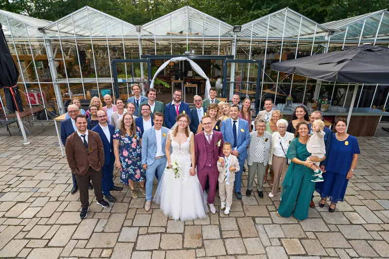 Groepsfoto met alle gasten voor de kas