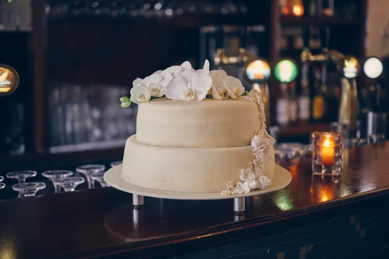 De witte bruidstaart op de bar