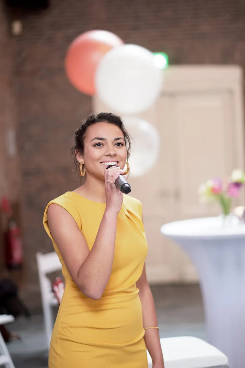Een gast spreekt het bruidspaar toe met de microfoon