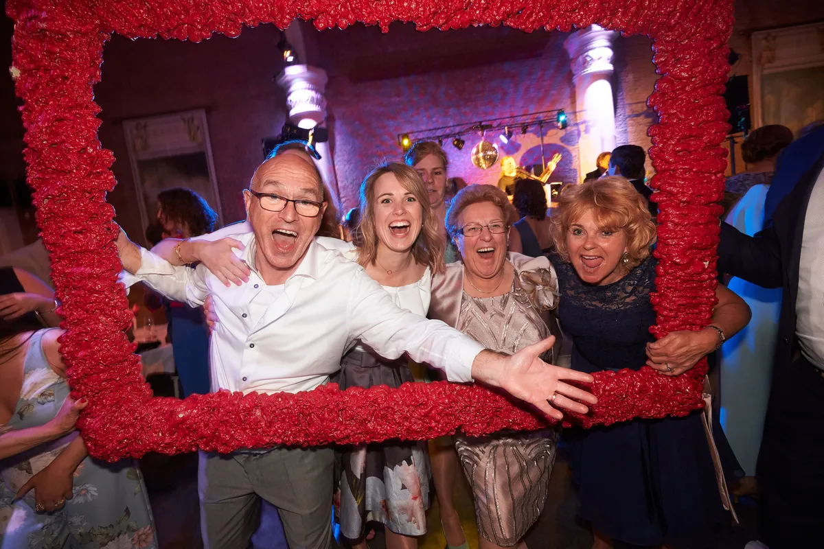 Gasten poseren in een grote lijst van rode rozen