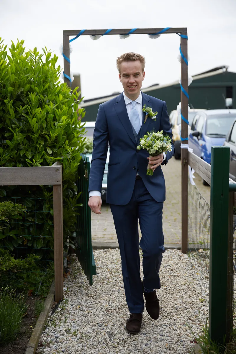 Coen loopt met het boeket over het erf van de boerderij