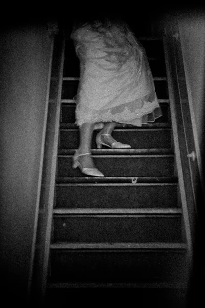 Debora in haar trouwjurk op de steile trap