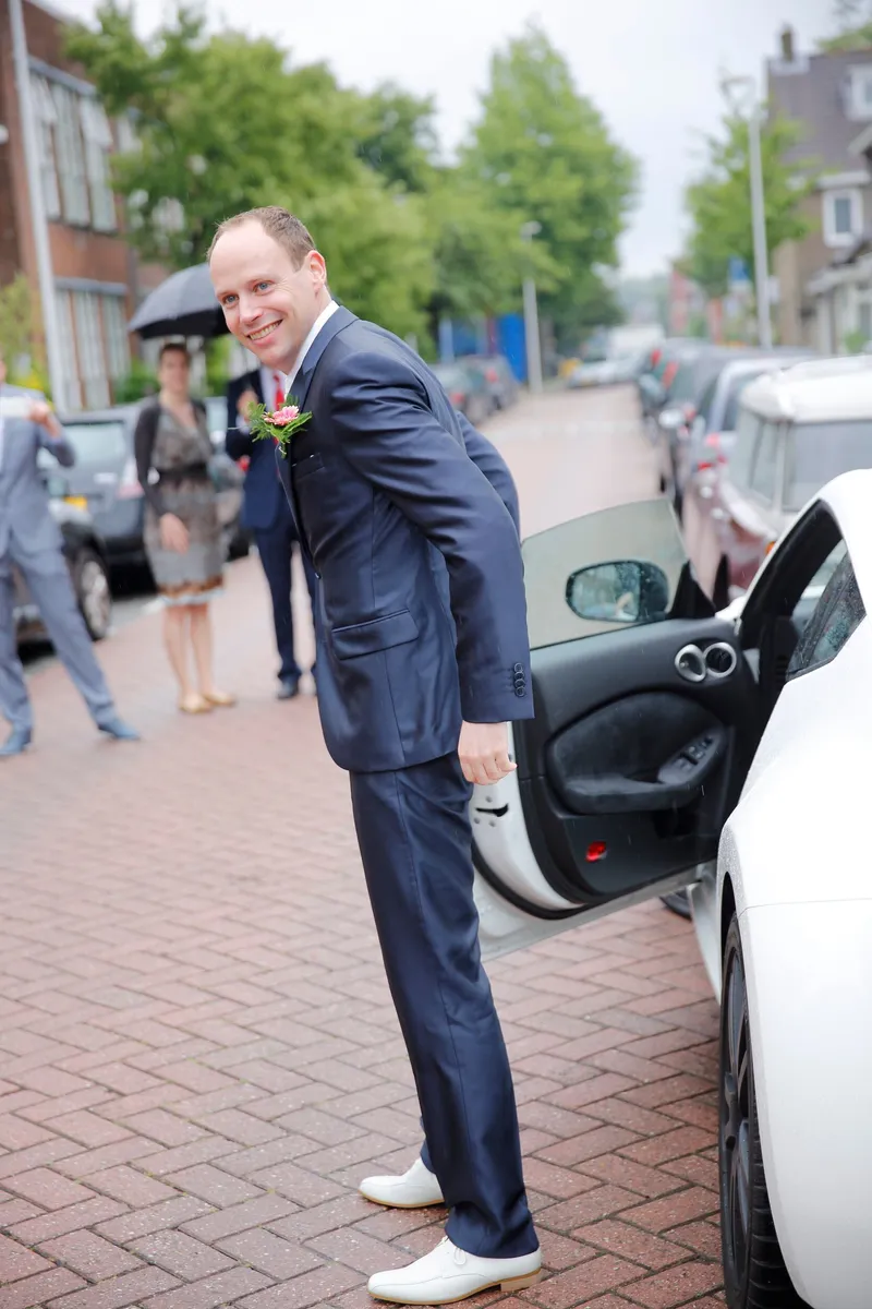 Wessel stapt uit de witte auto in de straat