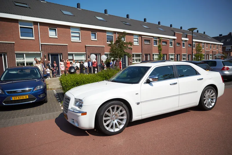 De witte trouwauto in de straat