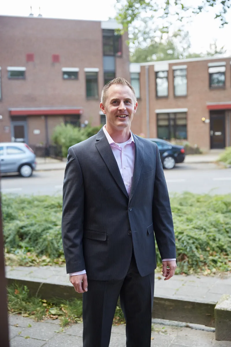 Tim wacht buiten in zijn pak