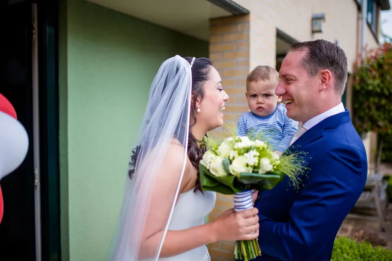 Hans met het boeket en hun zoontje op de arm