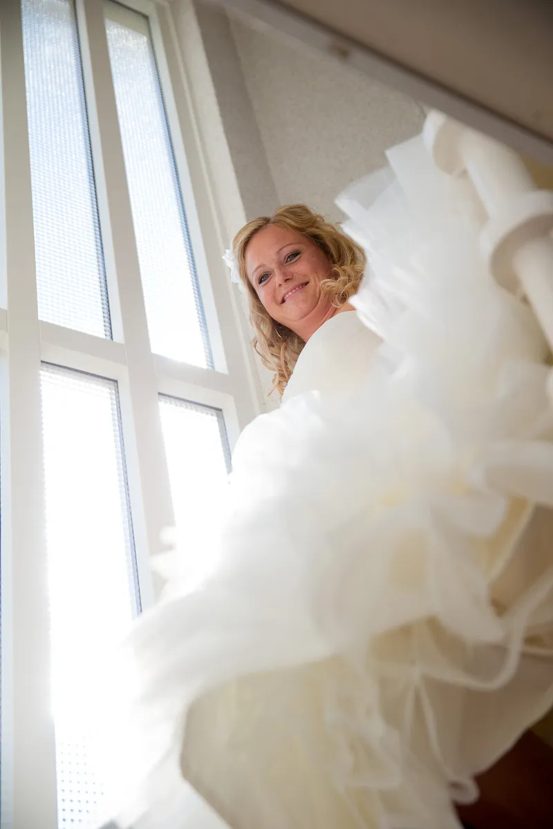 Sabine in haar jurk bij het raam, in het daglicht