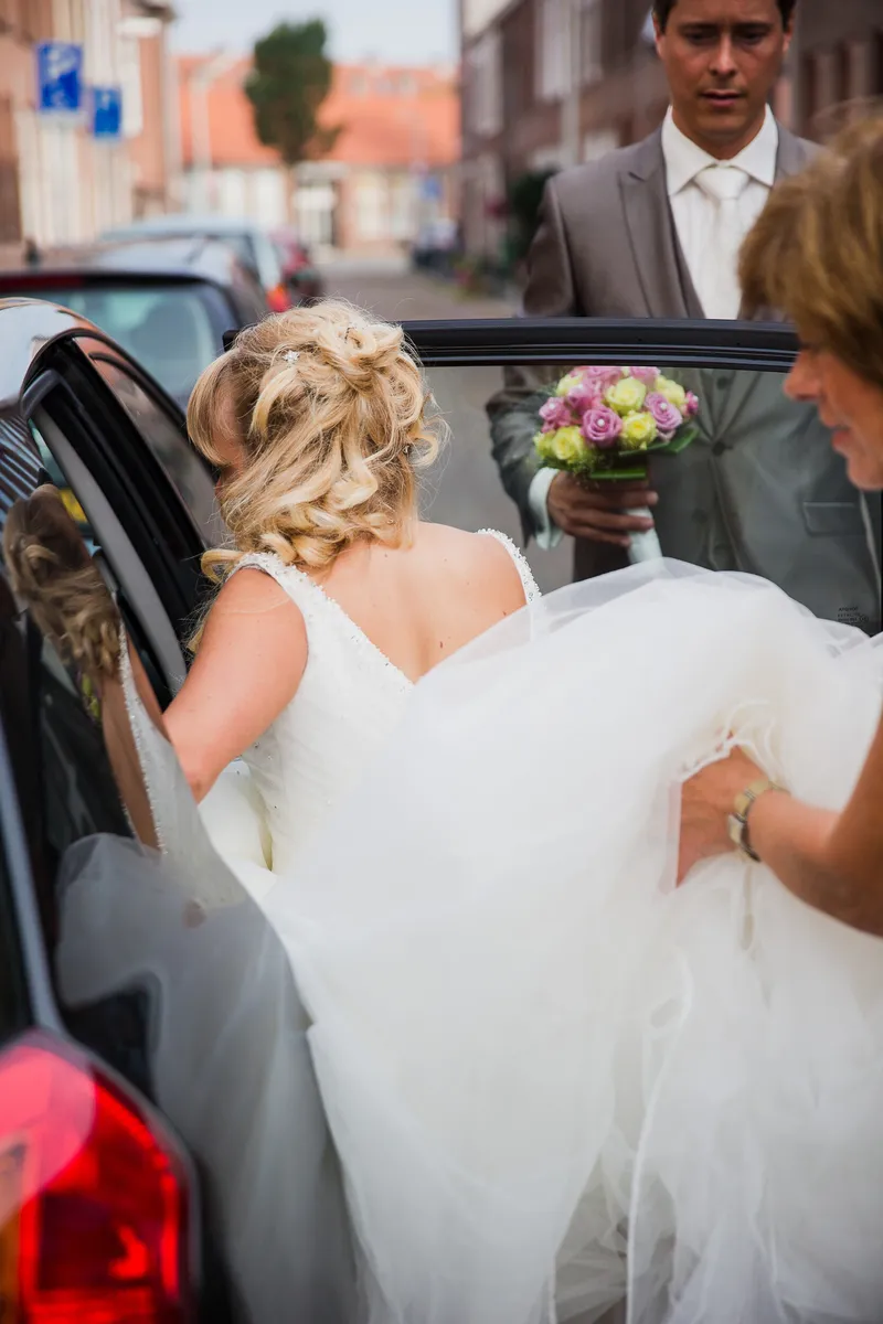 Linda stapt in de auto, haar jurk wordt opgetild